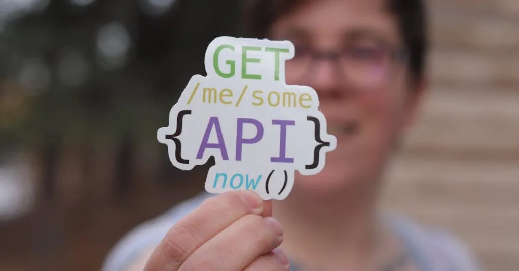 Close-up of a person holding a colorful API-themed sticker with trees blurred in the background.
