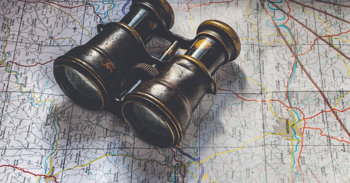 Close-up of antique binoculars placed on a detailed map, evoking adventure.