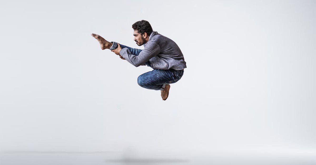 A male contemporary dancer gracefully leaps with precision and energy in a studio setting.