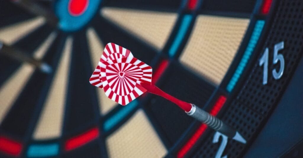 A dart striking the bullseye on a dartboard, showcasing precision and accuracy.