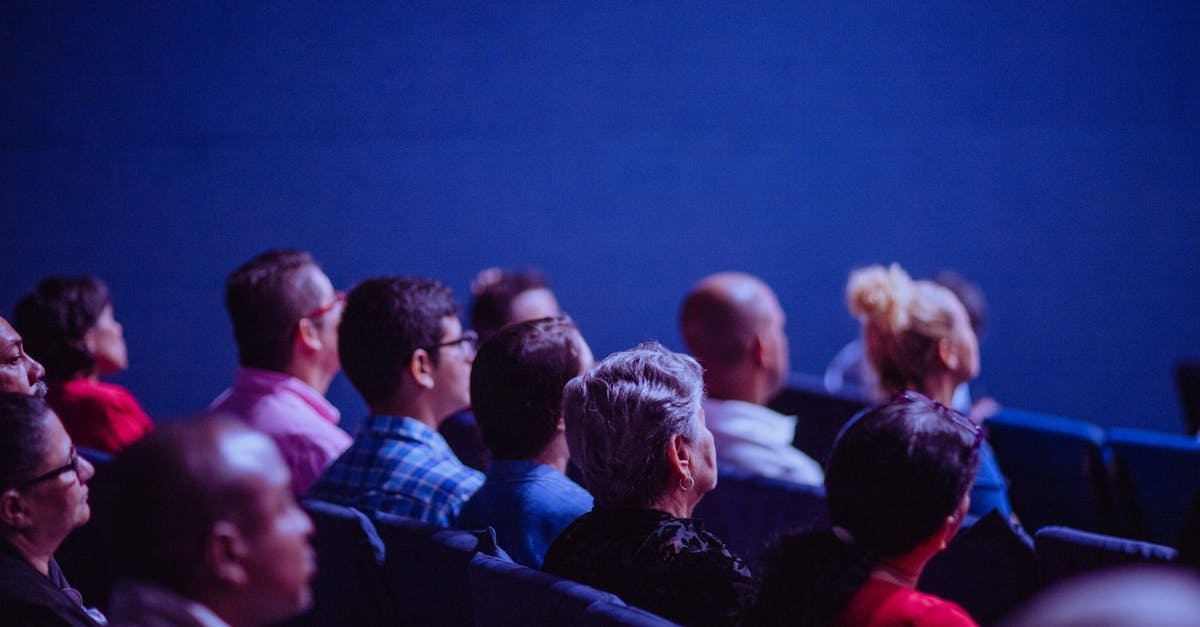 An attentive group of adults seated at an indoor conference, focusing on a presentation.