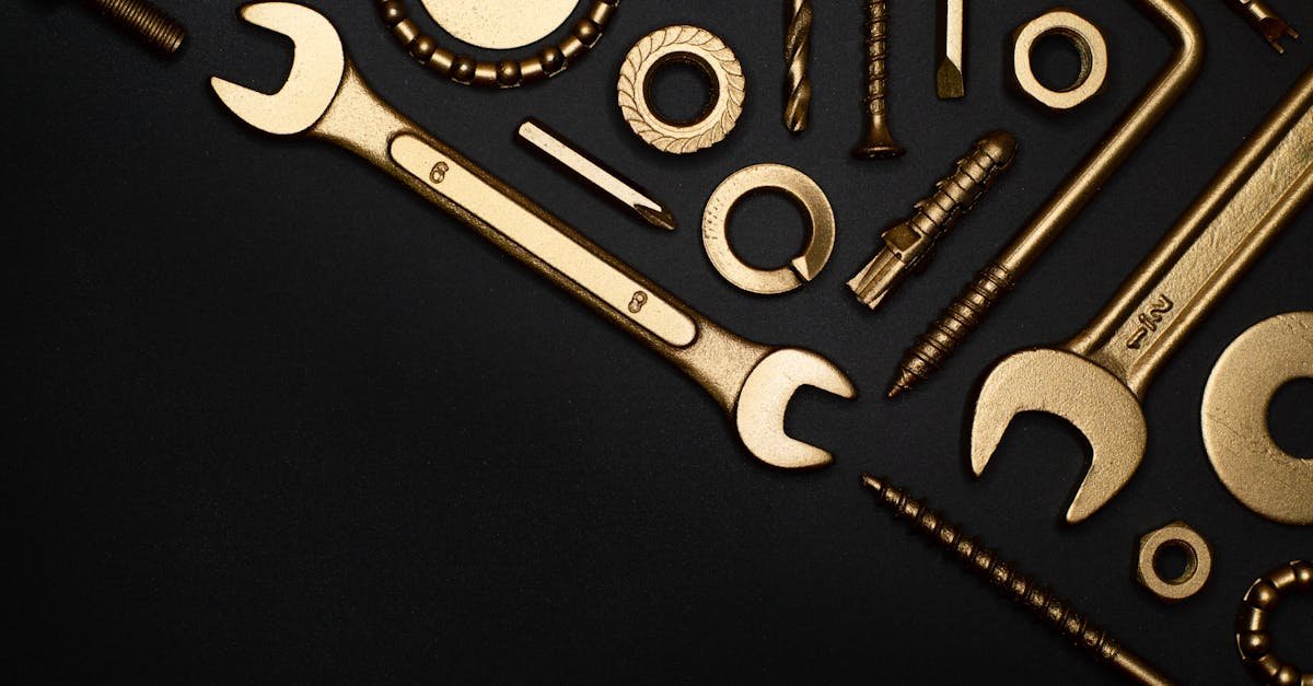 A collection of golden tools arranged in a flat lay on a black surface, perfect for industrial themes.