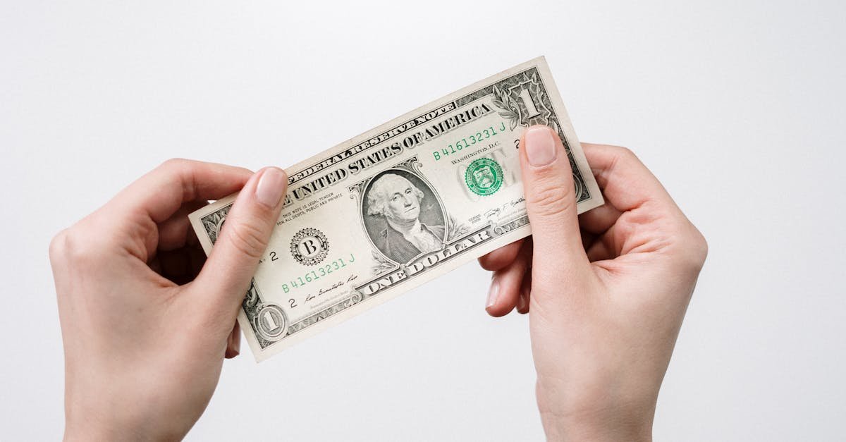 Hands holding a one dollar bill, depicting currency and finance closely.