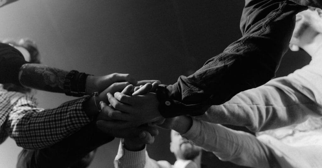 A group of diverse hands united in a gesture of teamwork and collaboration.