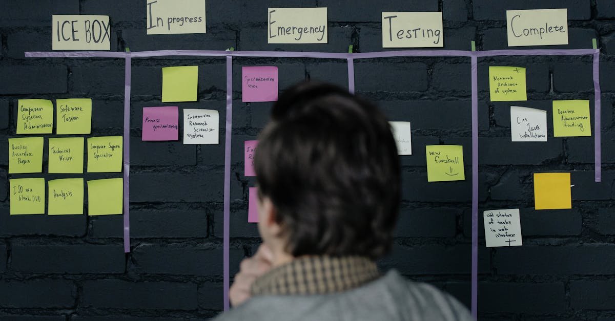 A man in an office reviews a scrum task board filled with sticky notes, planning strategy and organization.