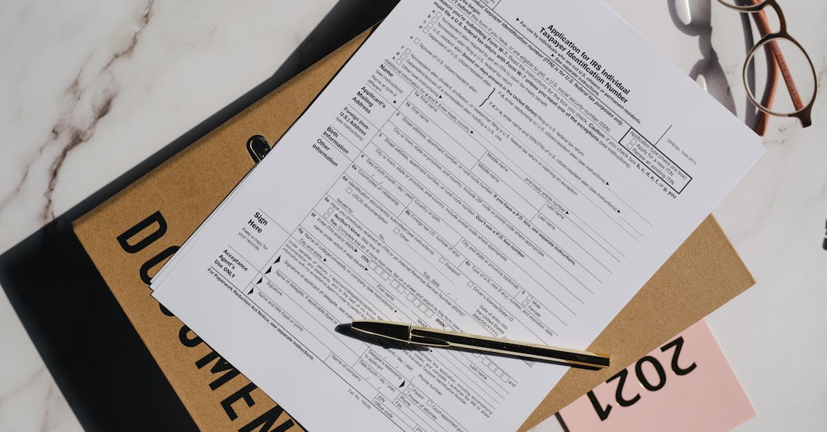 Top view of a tax form with a pen and eyeglasses on a marble surface, perfect for finance themes.