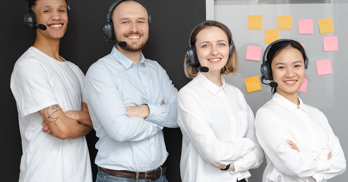 Team of diverse call center professionals smiling and standing confidently with headsets and microphones.