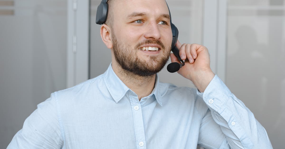 Smiling call center agent wearing a headset providing customer service in an office environment.