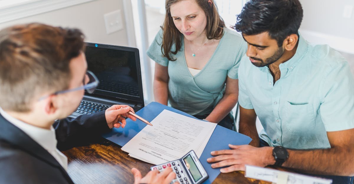 Young couple meeting with real estate agent to discuss property purchase.