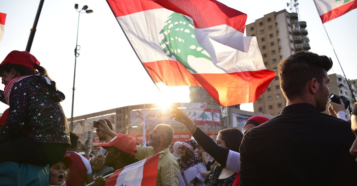 A vibrant rally in Tripoli, Lebanon, showcasing patriotism with waving national flags at sunset.