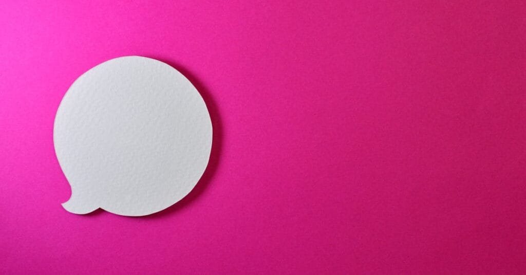 Minimalist pink background with a white speech bubble for creative design projects.
