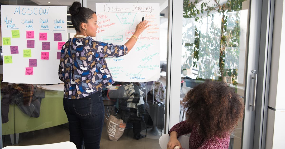 Two women collaborating on project strategy using notes in modern office.