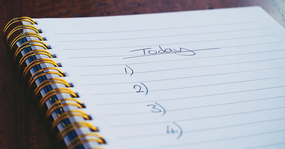 A close-up view of a handwritten to-do list on a spiral notebook with numbers for tasks.