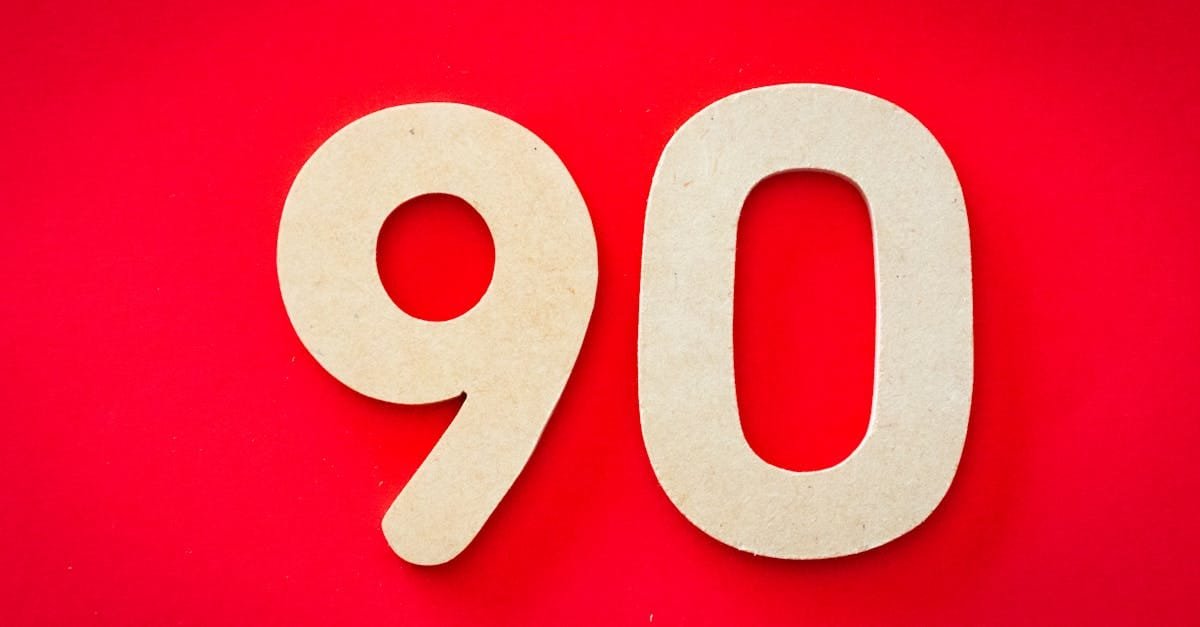Minimalist depiction of wooden numbers '90' against a vivid red backdrop, capturing simplicity and elegance.