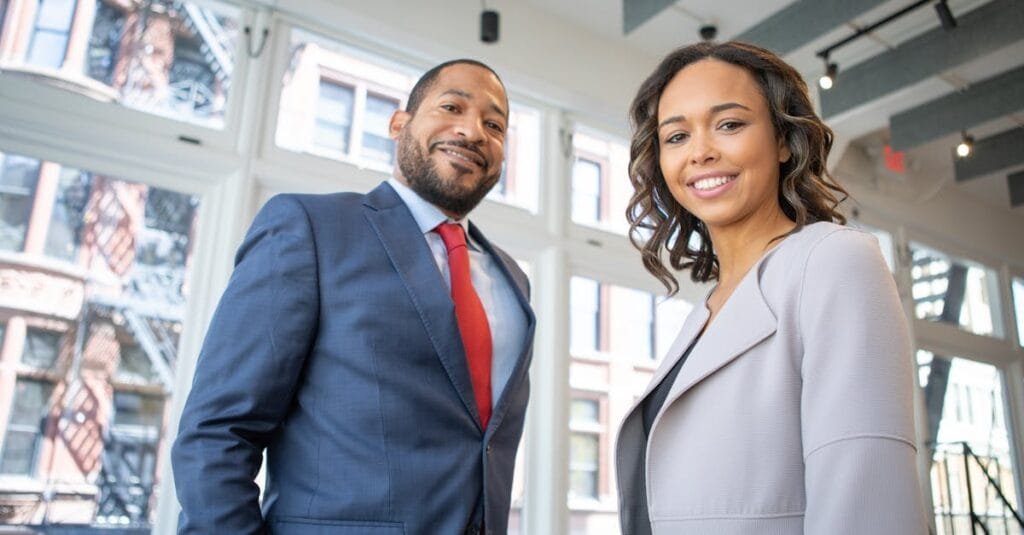Business professionals smiling in a modern Detroit office setting.