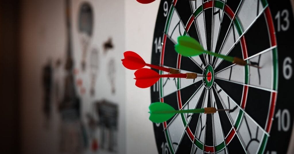 Close-up of a dartboard with multiple darts hitting the target, emphasizing precision and focus.