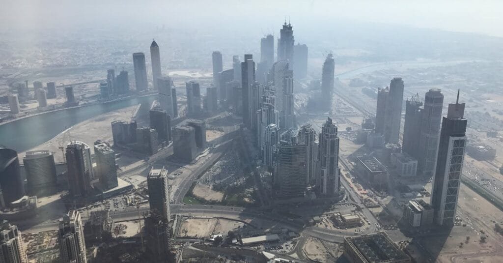 Stunning aerial view of Dubai's skyscrapers and modern architecture under a hazy sky.