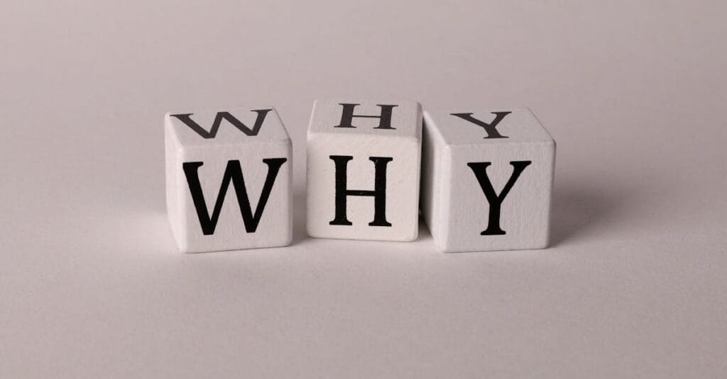 Close-up of lettered dice spelling 'WHY' on a neutral background, ideal for concepts of inquiry or curiosity.