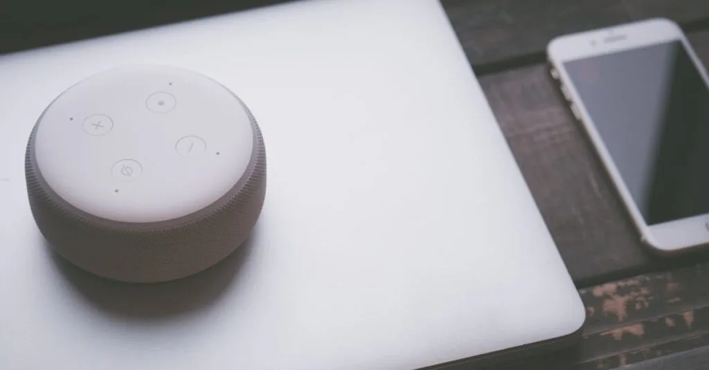A smart speaker, laptop, and smartphone array representing modern technology lifestyle on a wooden surface.