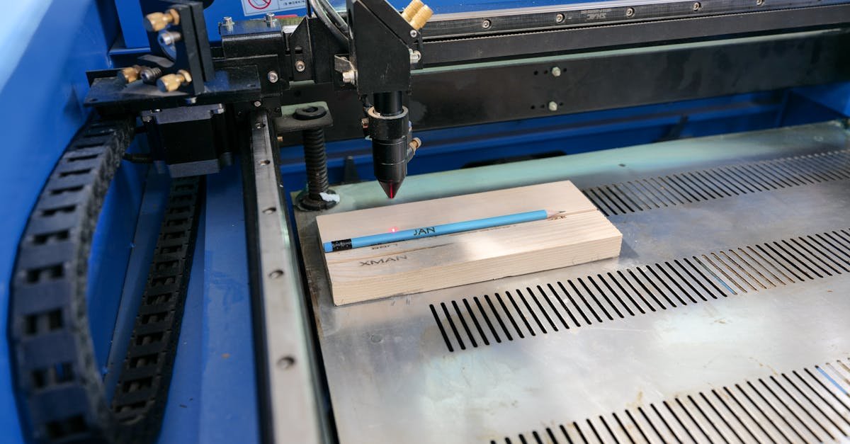 Laser engraving machine in action on wood with pencil for precise marking.