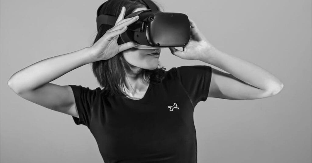 Black and white portrait of a young woman using a VR headset.