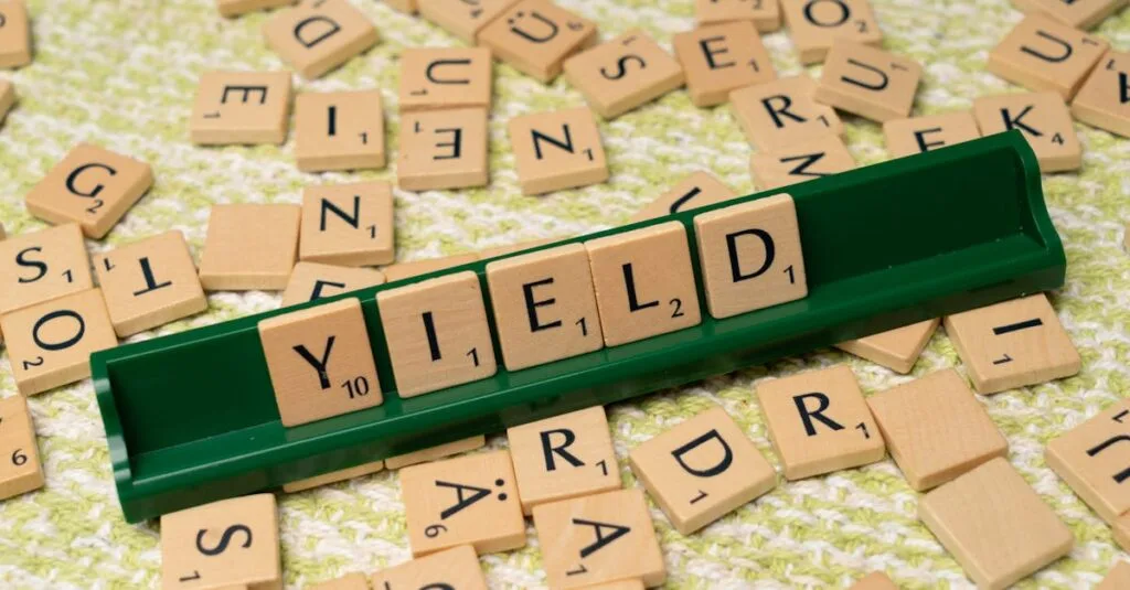 Scrabble tiles spelling 'Yield' on a rack among scattered letters.