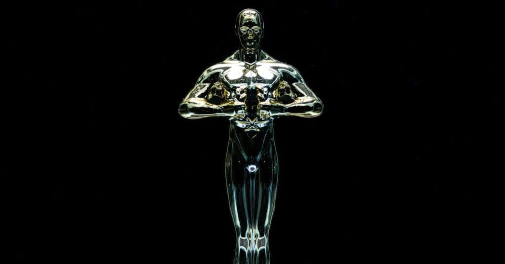 A golden trophy statue isolated on a black background symbolizing achievement and victory.