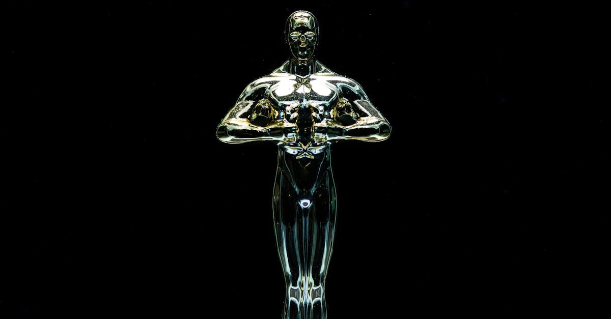 A golden trophy statue isolated on a black background symbolizing achievement and victory.