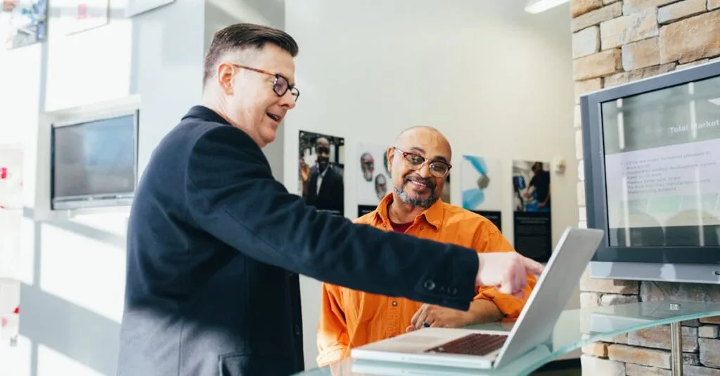 Two businessmen having a lively discussion in a modern office setting, pointing at a laptop screen.