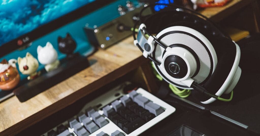 A modern desktop setup featuring stylish headphones, keyboard, and decorative figurines for a cozy tech workspace.