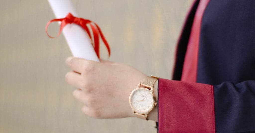 A close-up of a graduate's hand holding a diploma, symbolizing success and achievement.