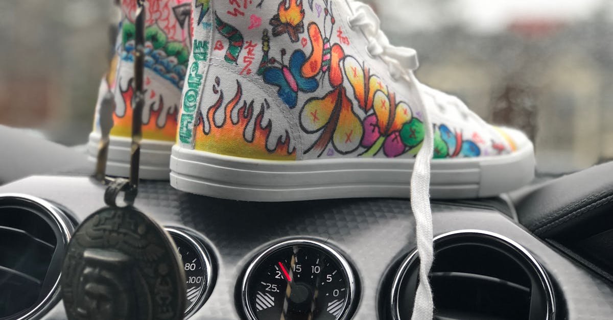 Vibrant graffiti sneakers displayed on a car dashboard, showcasing urban art style.