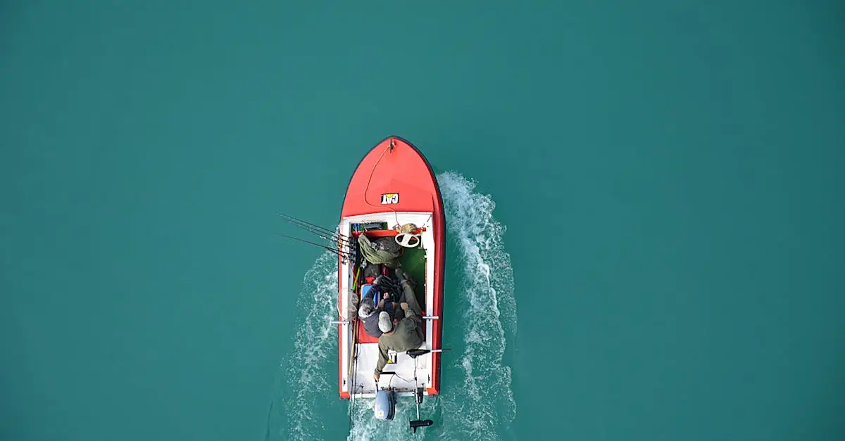 Top view of a red motorboat with fishermen navigating open turquoise waters.