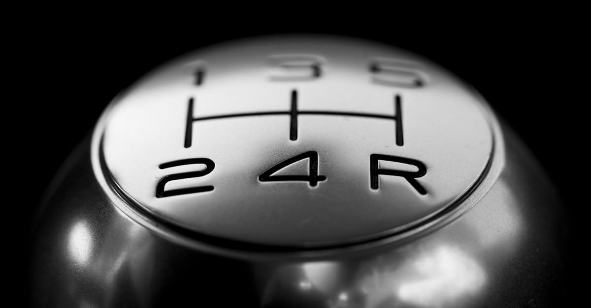 Detailed close-up of a stainless steel gear shift knob against a black background.