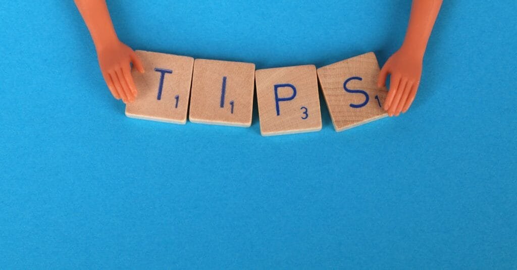 Scrabble tiles spelling 'TIPS' on a blue background, ideal for creative concepts.