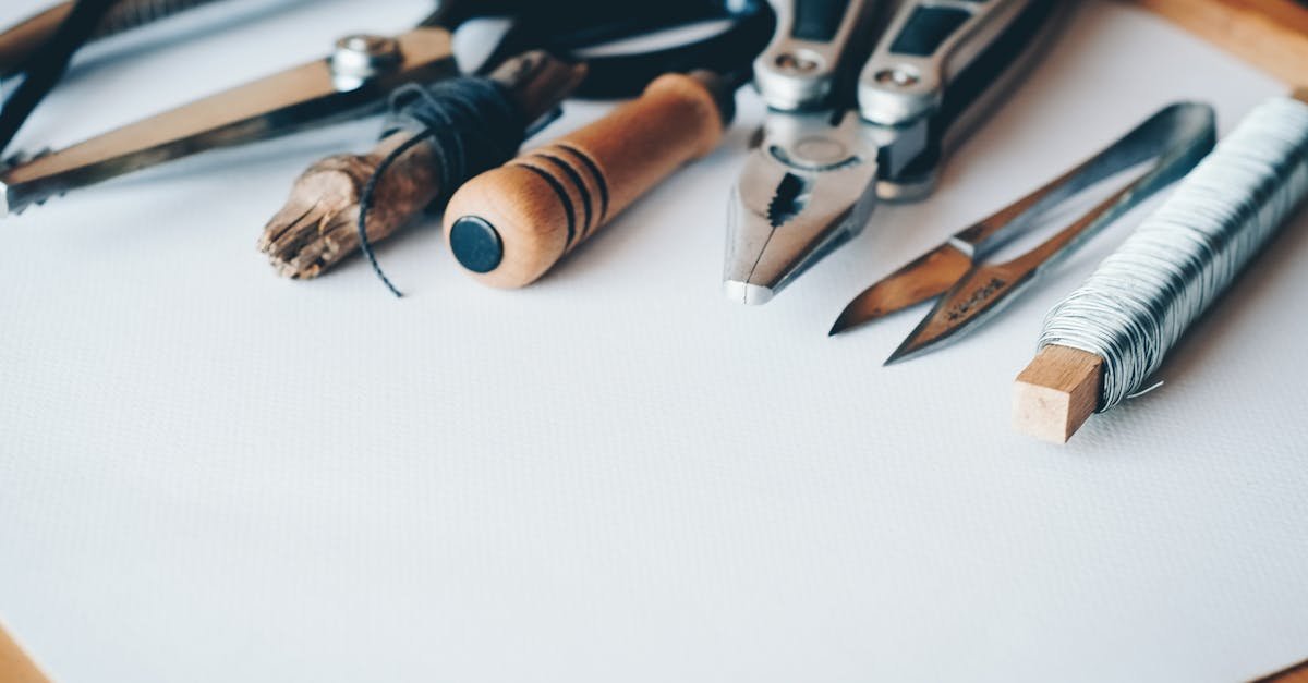 A selection of artisan tools and handmade crafts displayed on a white desk, perfect for creative projects.