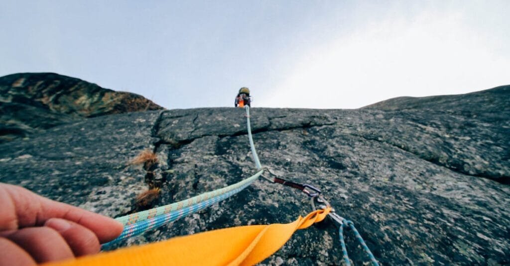 Capture the thrill of rock climbing with this dynamic low-angle shot showcasing determination and teamwork.
