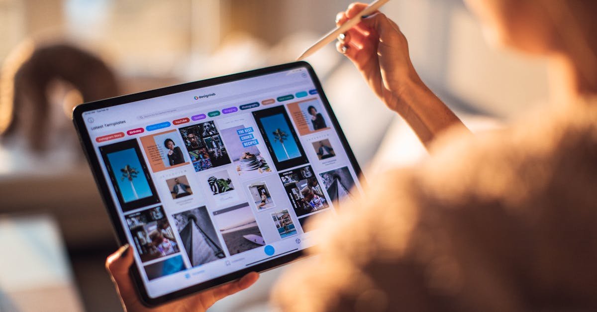A person uses a digital tablet with a stylus indoors in a warm, cozy setting.