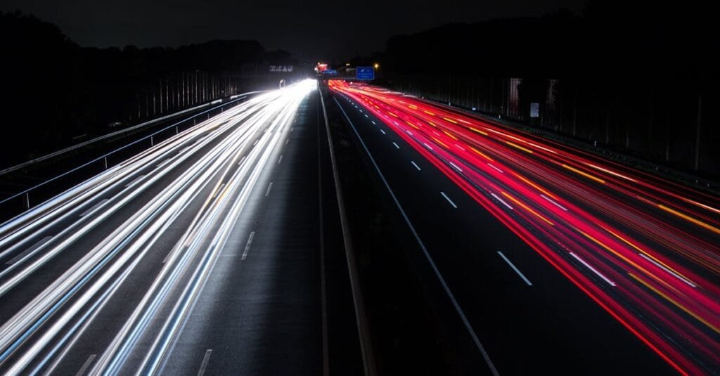 Long exposure of colorful light trails on a highway, capturing the night motion.