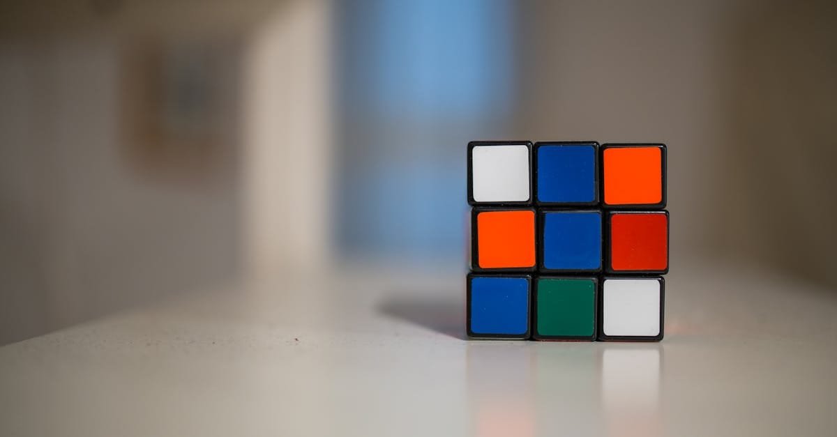 A close-up of a partially solved Rubik's Cube on a white table indoors.