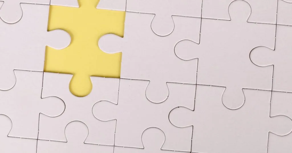 Close-up of a white jigsaw puzzle with a single yellow piece missing, symbolizing incompleteness.