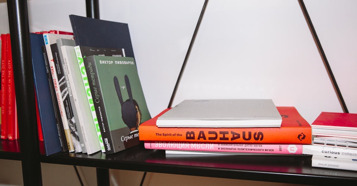 A variety of hardcover books neatly arranged on a modern bookshelf indoors.