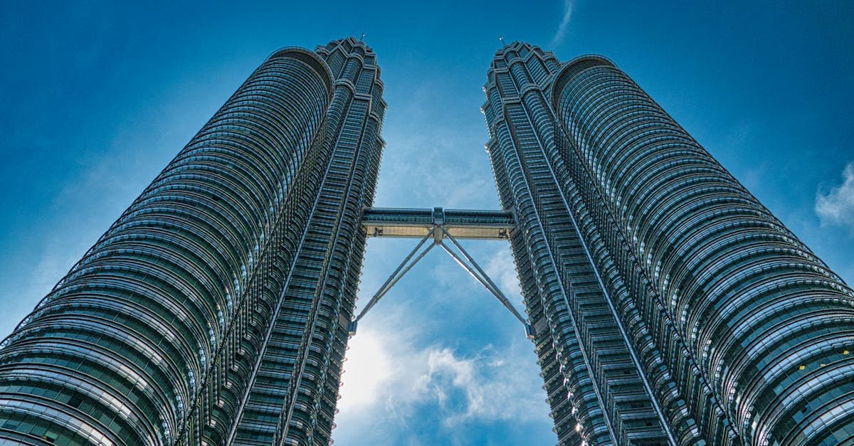 A vibrant view of the iconic Petronas Towers against a clear blue sky in Kuala Lumpur, Malaysia.