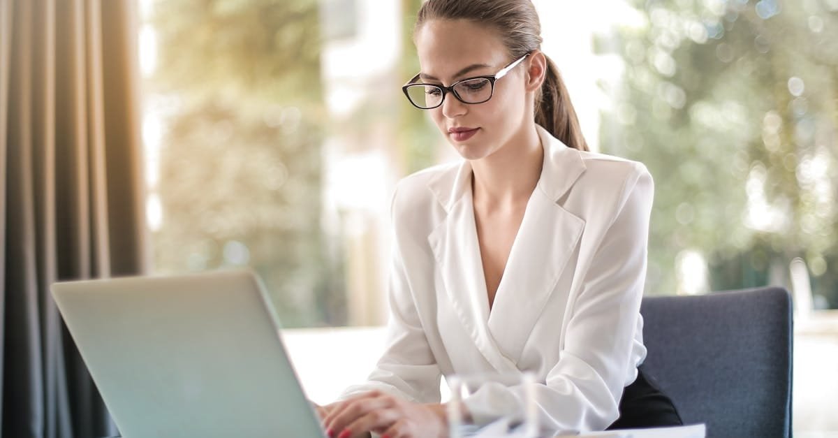 Confident businesswoman using a laptop at her desk, focused on her work.