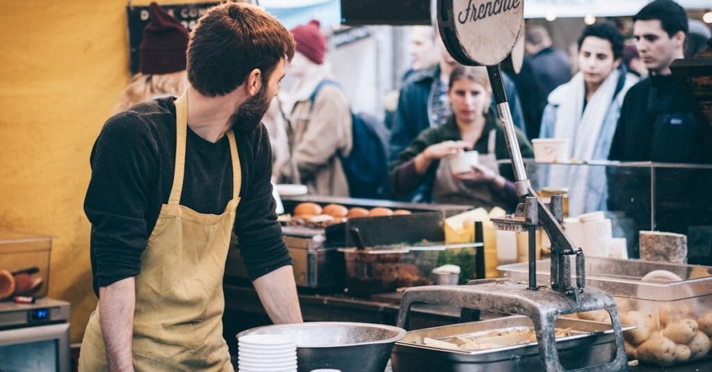 Dynamic scene of a street food vendor working in a busy market, engaging with diverse customers.
