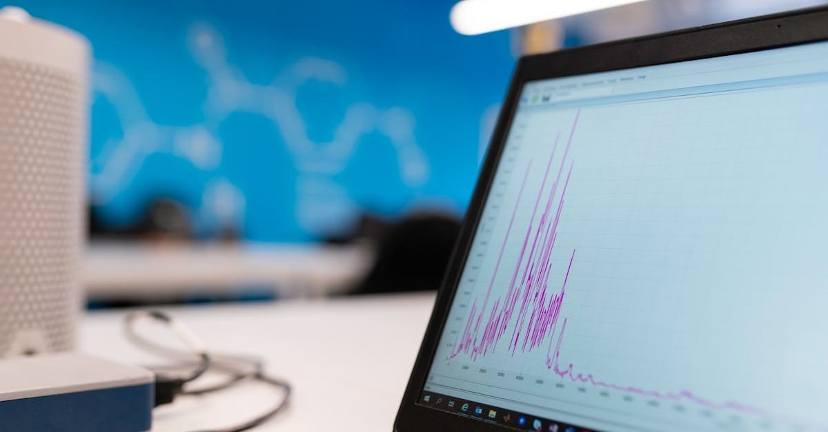 Laptop displaying data analytics graph in a modern office setting, symbolizing growth and technology.
