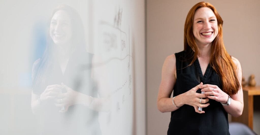 Confident businesswoman smiling during a corporate presentation in a modern office setting.