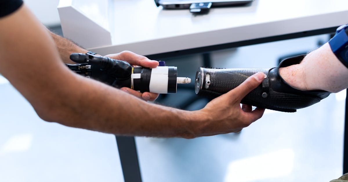Person helping another attach a prosthetic arm, showcasing technology and support.
