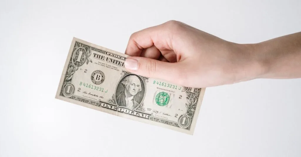 Close-up of a hand holding a one US dollar bill against a white background. Ideal for finance-related themes.