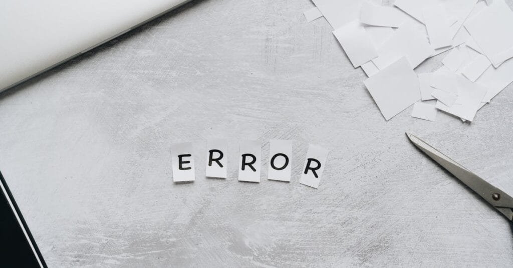 Creative concept showing the word 'error' with cut out letters on a table with scissors and paper.